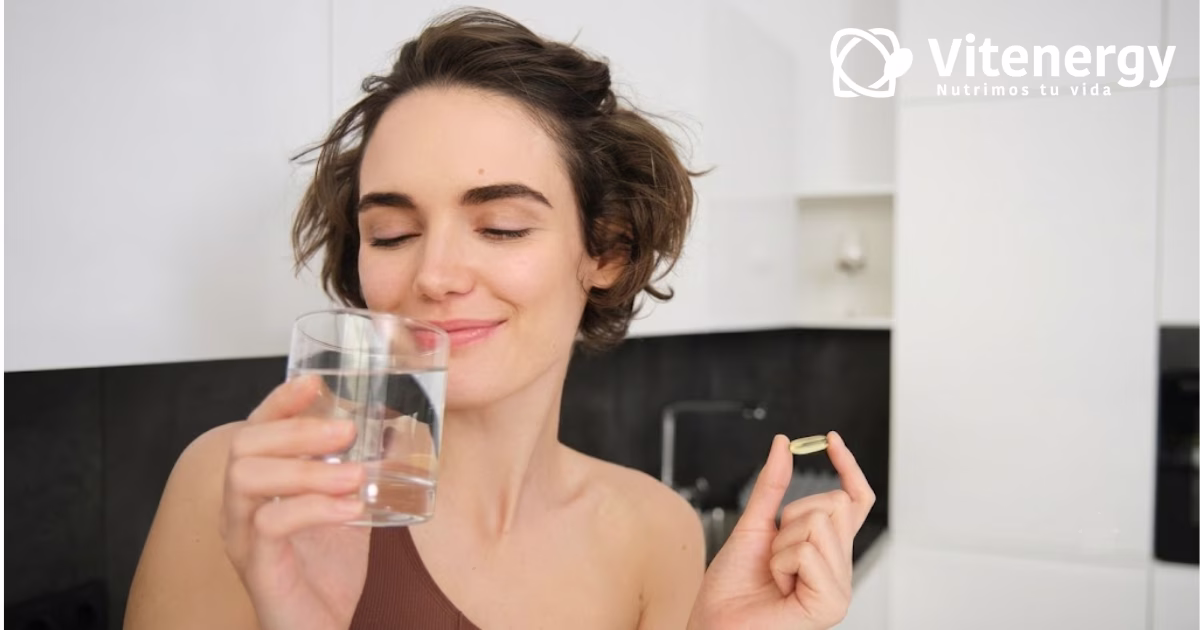 Mujer tomando suplemento de magnesio quelado Vitenergy para mejorar la energía celular y bienestar diario.